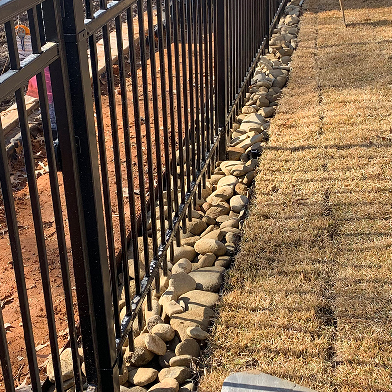 decorative steel fence with rock perimeter